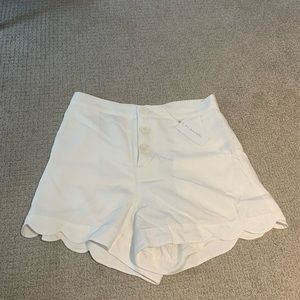 Flannel brand white linen shorts with embroidered detailing on back pockets
